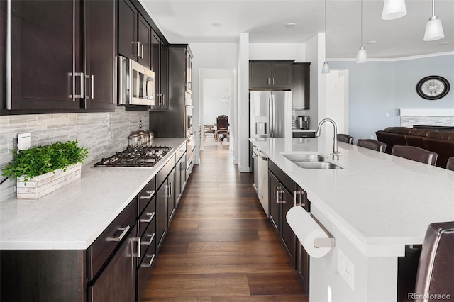 kitchen with dark wood-type flooring, a large island, a sink, tasteful backsplash, and stainless steel appliances