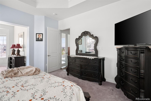 bedroom featuring baseboards, light carpet, and a raised ceiling