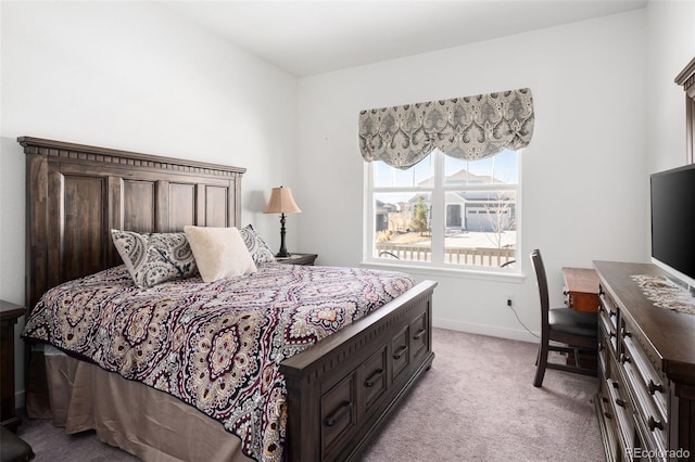 bedroom with light colored carpet and baseboards