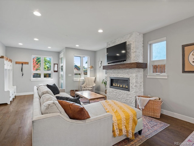 living room with dark hardwood / wood-style flooring and a fireplace