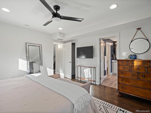 bedroom featuring light wood-type flooring, ensuite bathroom, and ceiling fan