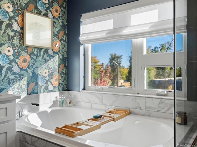 bathroom with a relaxing tiled tub and a wealth of natural light