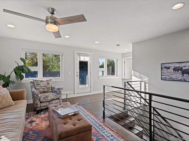 living room featuring ceiling fan and dark wood-type flooring