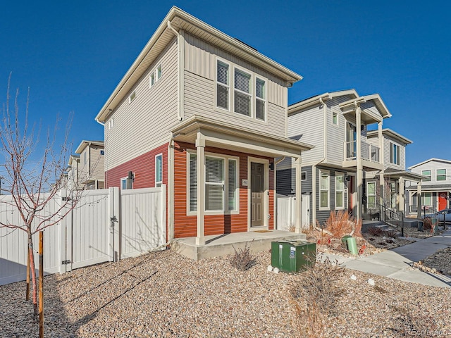 view of front of house featuring board and batten siding, covered porch, fence, and a gate