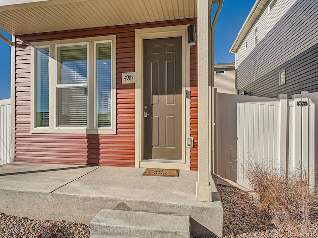 doorway to property featuring fence