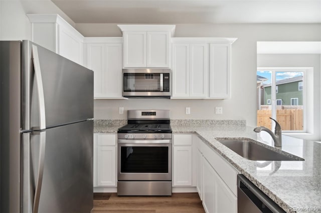 2320 Christina St, Fort Lupton, CO 80621 - kitchen featuring stainless steel appliances, white cabinets, a sink, and light stone counters