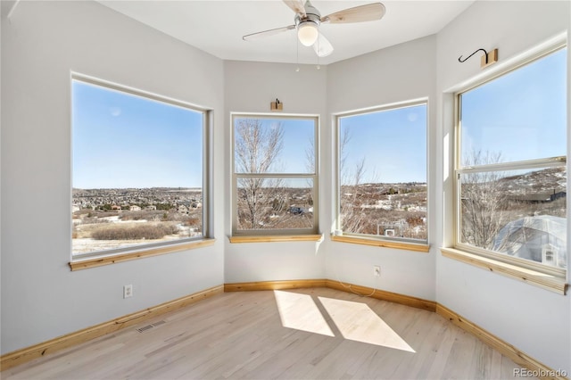 unfurnished sunroom with ceiling fan, plenty of natural light, and visible vents