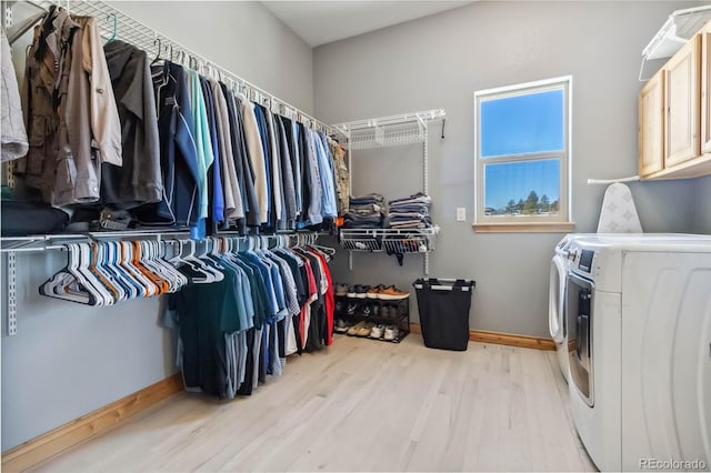 spacious closet with light wood-type flooring and washing machine and clothes dryer