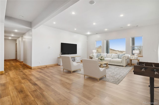 living room featuring light wood-type flooring, baseboards, and recessed lighting