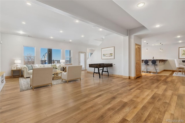 living area with vaulted ceiling with beams, light wood-style floors, baseboards, and recessed lighting