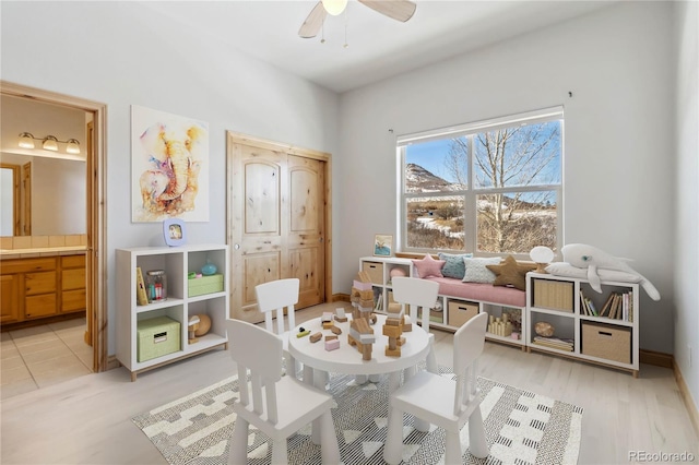 game room with ceiling fan and baseboards