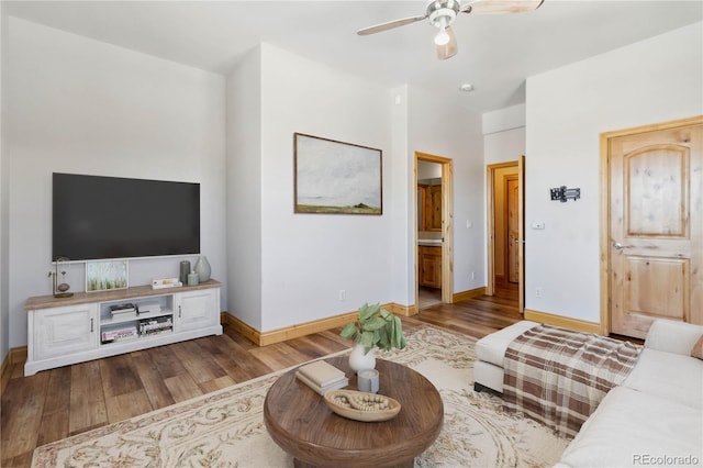 living room with baseboards, a ceiling fan, and wood finished floors