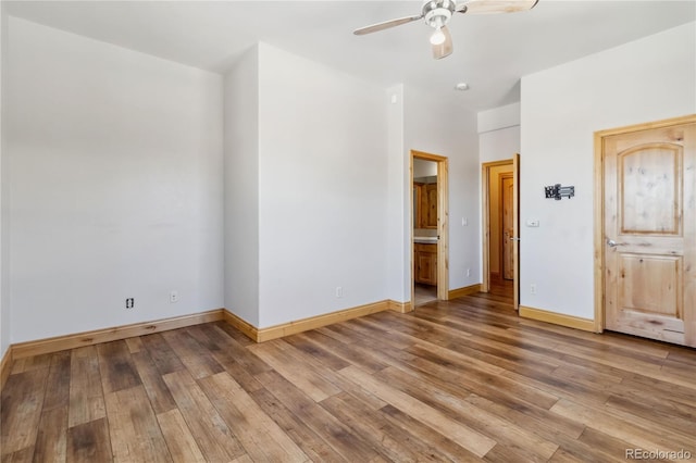 interior space with light wood-style floors, ensuite bath, and baseboards