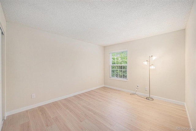 10251 W 44th Ave Unit 3-204, Wheat Ridge, CO 80033 - spare room featuring light wood-type flooring, a textured ceiling, and baseboards