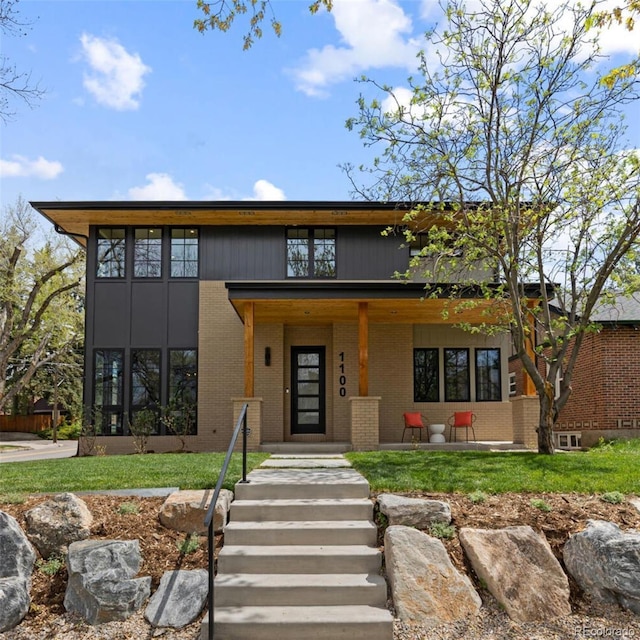 1100 S Elizabeth St, Denver, CO 80210 - view of front of house featuring brick siding, covered porch, and a front yard
