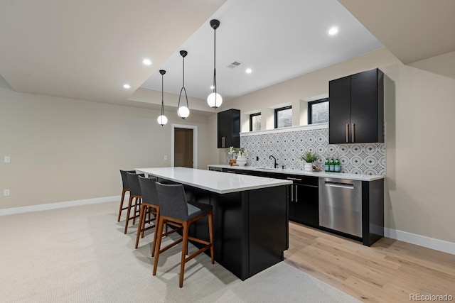 1100 S Elizabeth St, Denver, CO 80210 - kitchen with dark cabinets, light countertops, stainless steel dishwasher, and a center island