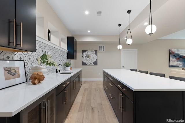 1100 S Elizabeth St, Denver, CO 80210 - kitchen with a sink, light countertops, light wood-style floors, and visible vents