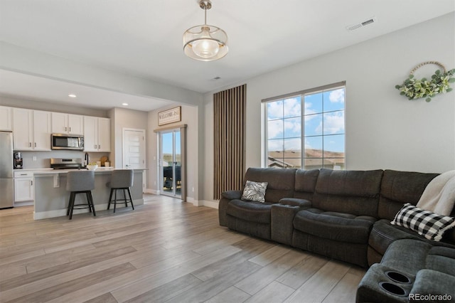 living room featuring visible vents, recessed lighting, light wood-type flooring, and baseboards