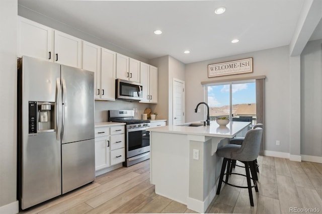 kitchen featuring white cabinetry, an island with sink, appliances with stainless steel finishes, and a sink