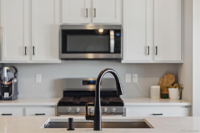 details featuring light countertops, white cabinets, and appliances with stainless steel finishes