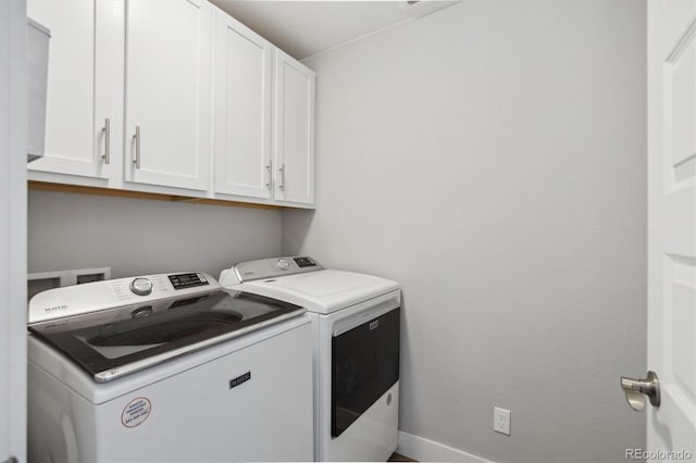 clothes washing area featuring cabinet space and separate washer and dryer