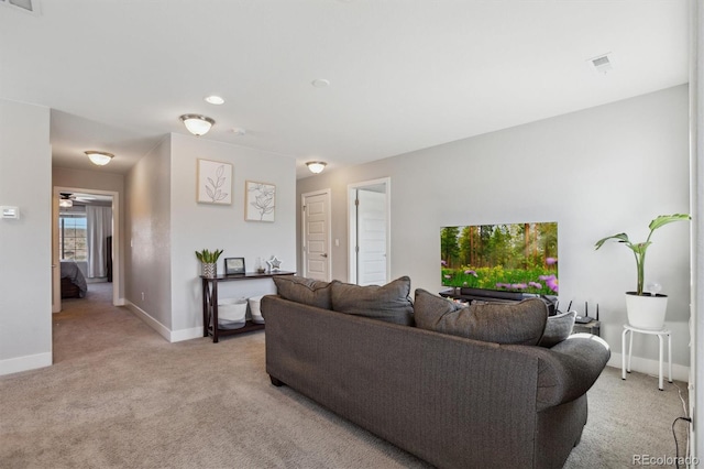 living room featuring visible vents, light colored carpet, baseboards, and ceiling fan