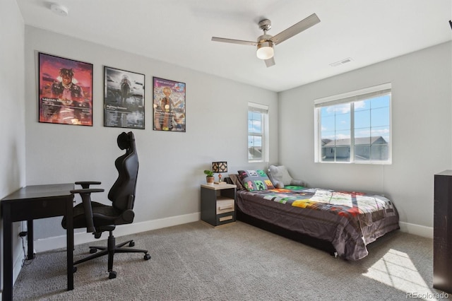 carpeted bedroom with a ceiling fan, baseboards, and visible vents