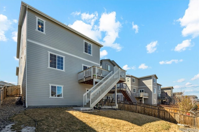 back of house featuring a fenced backyard, stairway, a lawn, and a deck