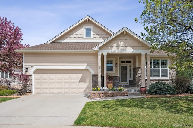 1844 S Jay Way, Lakewood, CO 80232 - craftsman house with stone siding, an attached garage, driveway, a front lawn, and roof with shingles