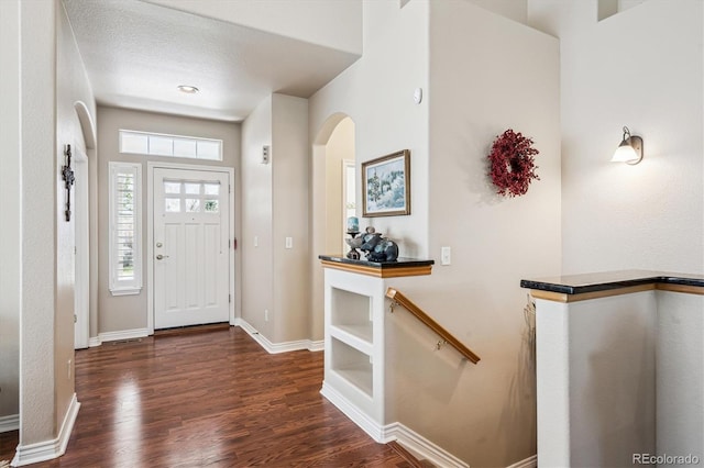 1844 S Jay Way, Lakewood, CO 80232 - foyer featuring arched walkways, dark wood-style floors, and baseboards
