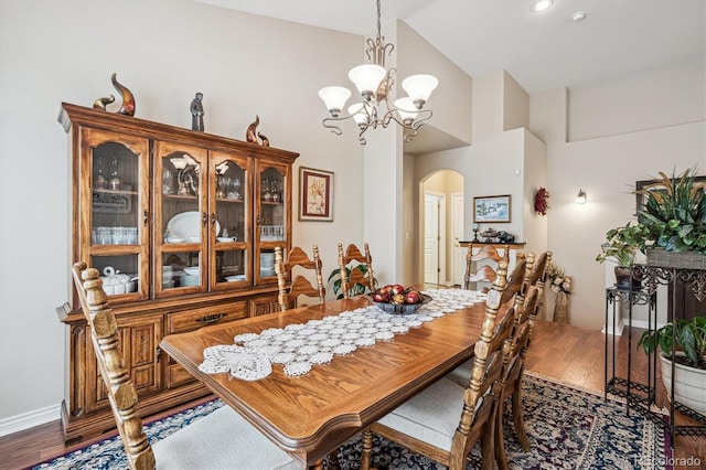 1844 S Jay Way, Lakewood, CO 80232 - dining area with an inviting chandelier, arched walkways, high vaulted ceiling, and wood finished floors