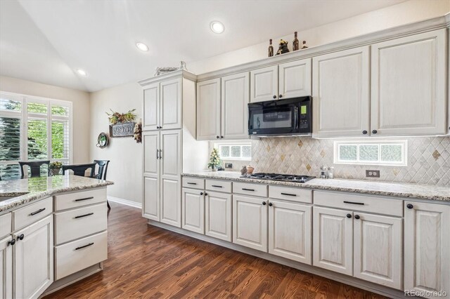 1844 S Jay Way, Lakewood, CO 80232 - kitchen featuring dark wood-type flooring, stainless steel gas stovetop, vaulted ceiling, tasteful backsplash, and black microwave