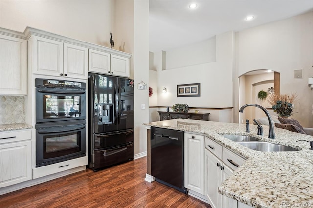 1844 S Jay Way, Lakewood, CO 80232 - kitchen featuring a sink, light stone counters, black appliances, dark wood-type flooring, and arched walkways