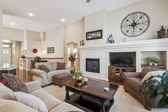 1844 S Jay Way, Lakewood, CO 80232 - living area with a towering ceiling, recessed lighting, light wood finished floors, arched walkways, and a tile fireplace