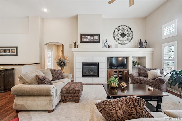 1844 S Jay Way, Lakewood, CO 80232 - living area featuring a tile fireplace, plenty of natural light, a ceiling fan, and arched walkways