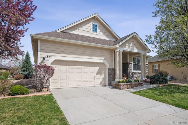 1844 S Jay Way, Lakewood, CO 80232 - craftsman inspired home with stone siding, concrete driveway, a garage, a front lawn, and a shingled roof