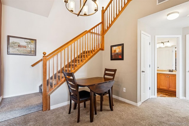 8778 S Kipling Way Unit 304, Littleton, CO 80127 - dining space featuring light carpet, a chandelier, stairs, and baseboards
