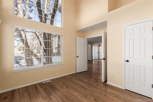 empty room featuring hardwood / wood-style flooring and a high ceiling