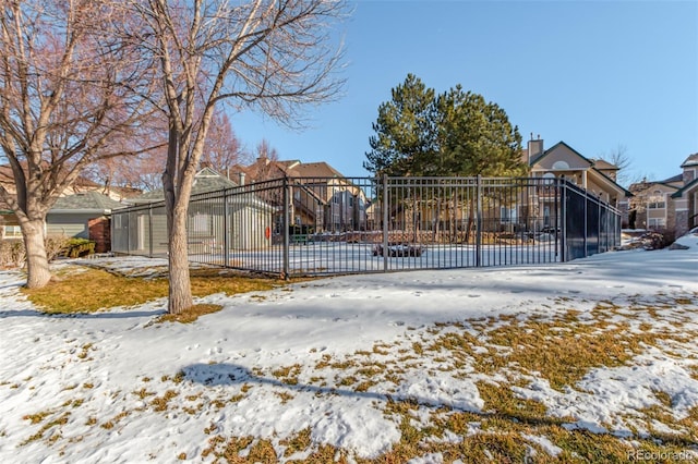 snow covered gate with fence and a residential view