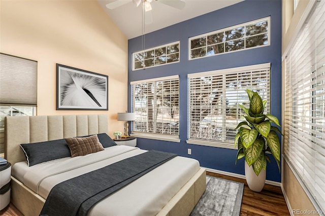 bedroom featuring baseboards, ceiling fan, high vaulted ceiling, and wood finished floors