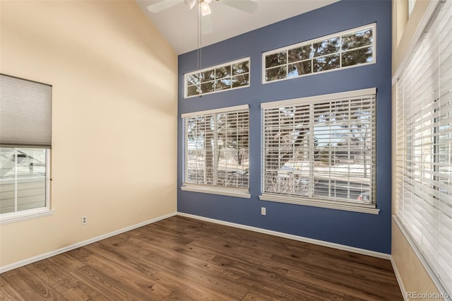 empty room with high vaulted ceiling, plenty of natural light, and wood finished floors