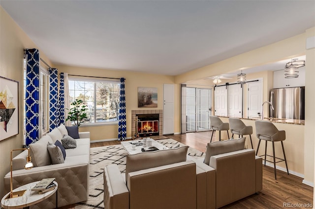 living area featuring a fireplace, wood finished floors, and baseboards