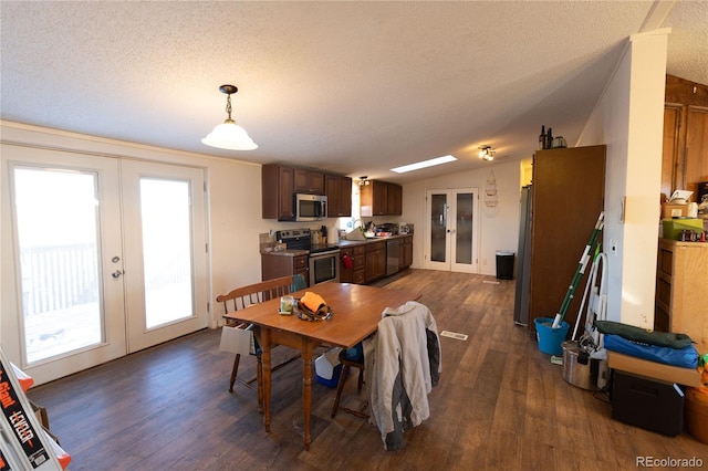 dining area with french doors, a textured ceiling, lofted ceiling, and dark hardwood / wood-style flooring