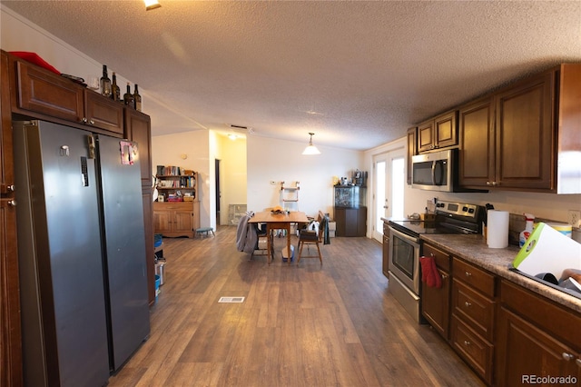 kitchen featuring appliances with stainless steel finishes, vaulted ceiling, dark hardwood / wood-style flooring, a textured ceiling, and decorative light fixtures