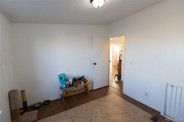 bedroom with a textured ceiling, crown molding, and radiator heating unit