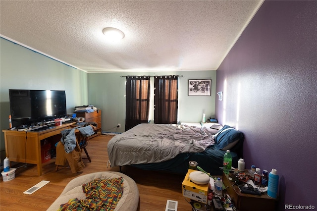 bedroom with a textured ceiling and hardwood / wood-style floors