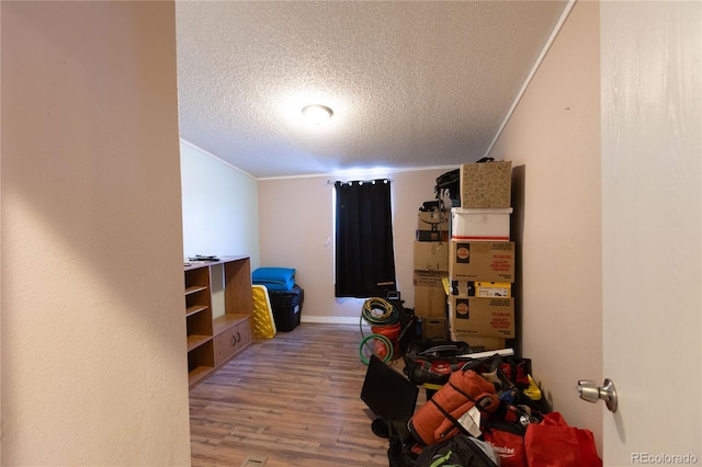 bedroom featuring a textured ceiling, crown molding, and hardwood / wood-style floors