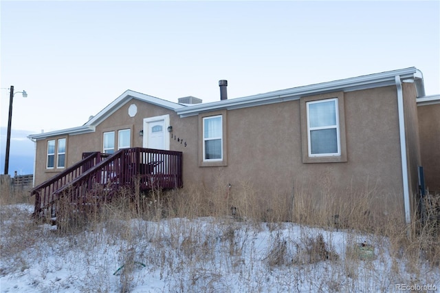 snow covered property featuring a deck