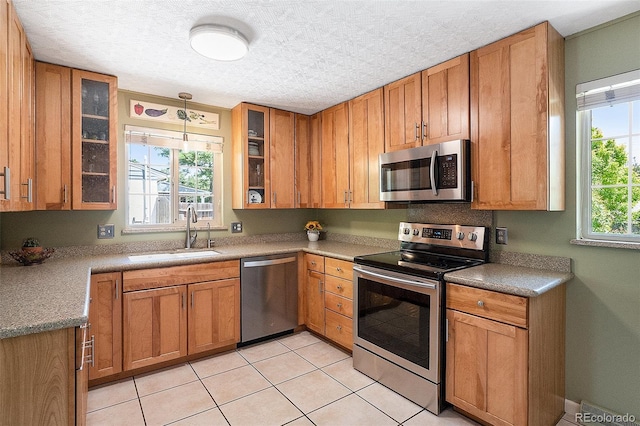 6868 S Birch Way, Centennial, CO 80122 - kitchen with appliances with stainless steel finishes, light tile patterned flooring, glass insert cabinets, and pendant lighting