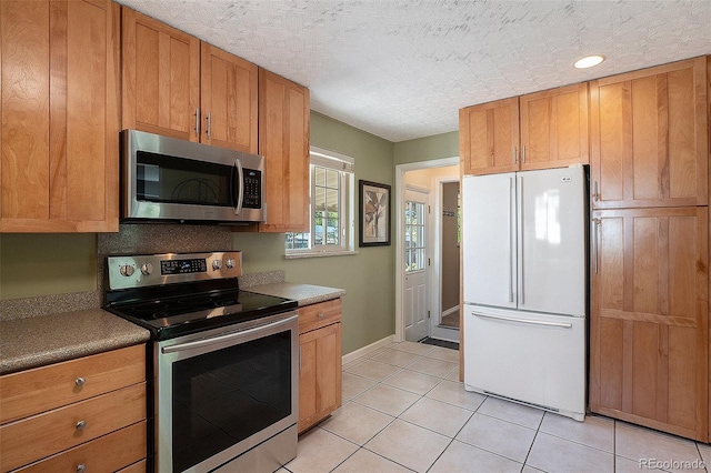 6868 S Birch Way, Centennial, CO 80122 - kitchen with stainless steel appliances, light tile patterned floors, and brown cabinetry